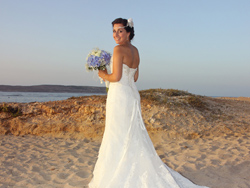 The bride having a stroll on the sandy beach after the civil wedding