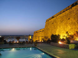 Lit up pool area with view of the Bastions